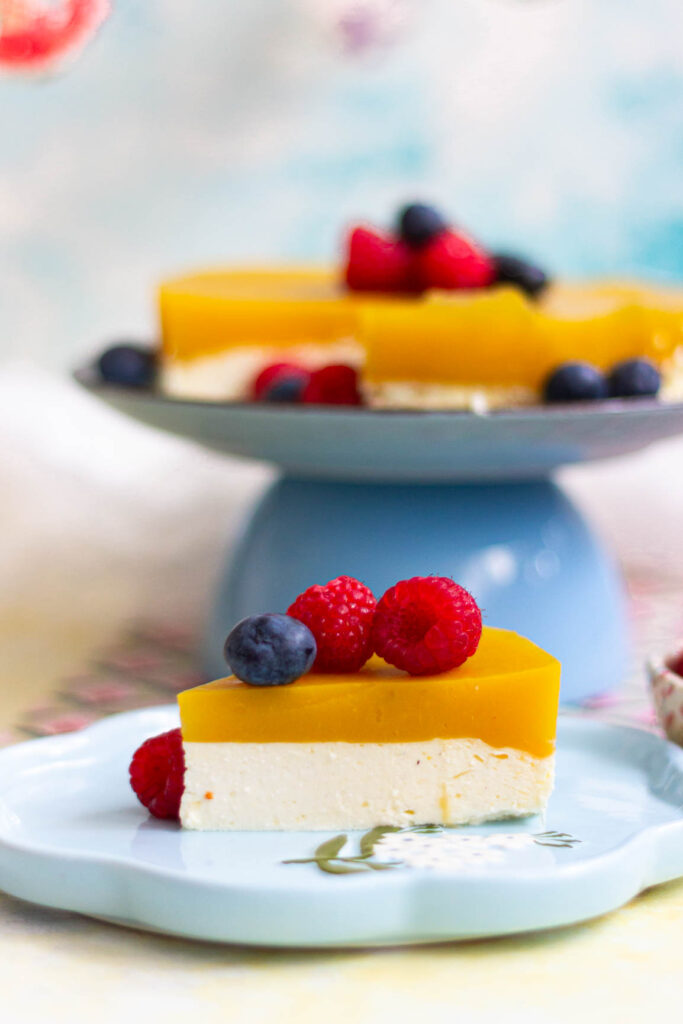 Kawałek skyrnika z mango z malinami i borówkami na talerzu