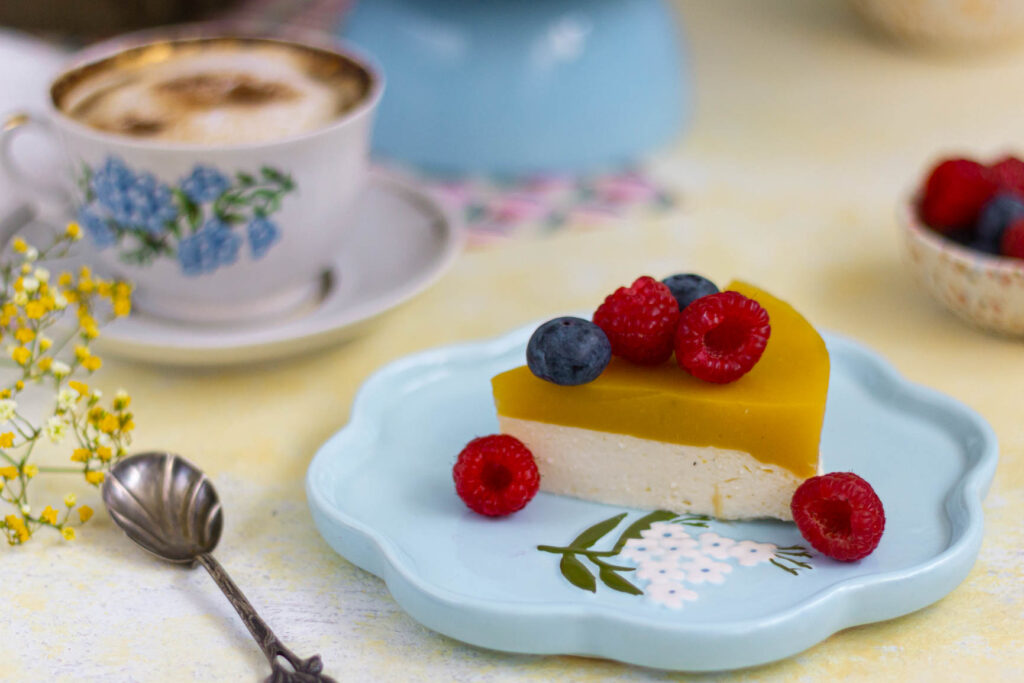 Kawałek skyrnika z mango z malinami i borówkami na talerzu