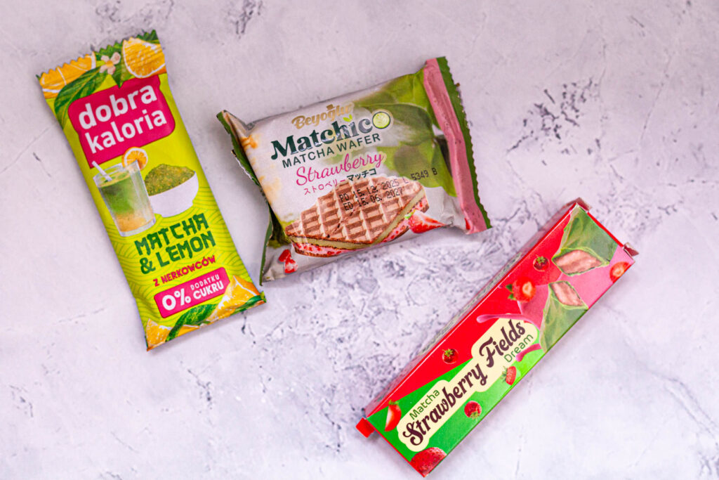Opakowania produktów spożywczych z dodatkiem matchy, w tym baton i wafle o smaku truskawkowym oraz cytrynowym