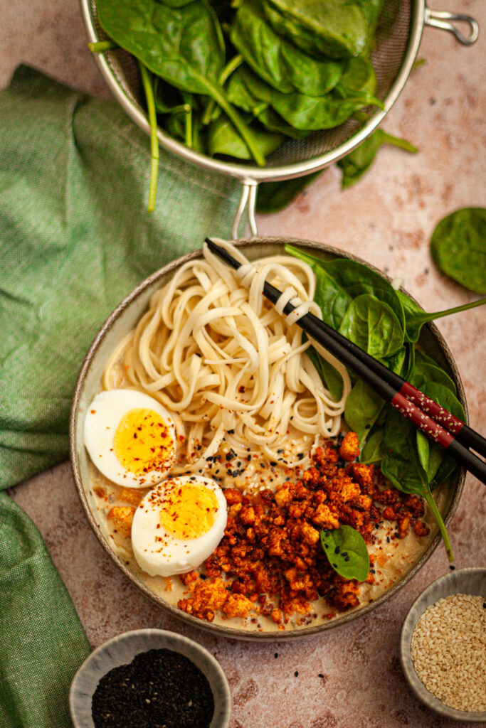 Ramen z tofu, makaronem, jajkiem na twardo, świeżym szpinakiem i sezamem w kremowej bazie.